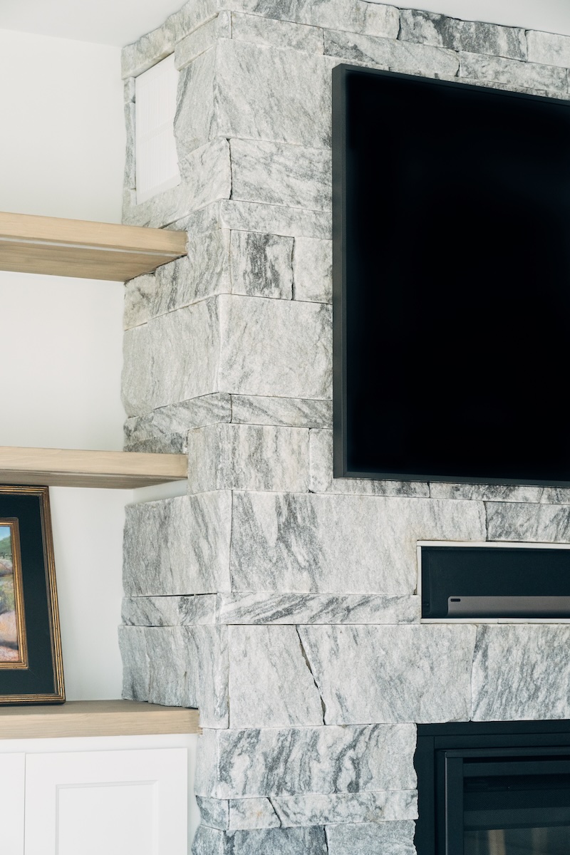 Berkshire™ Georgia Marble Pearl Grey split-face thin veneer fireplace column detail — mixed coursing heights with sawn edges, interior living room installation